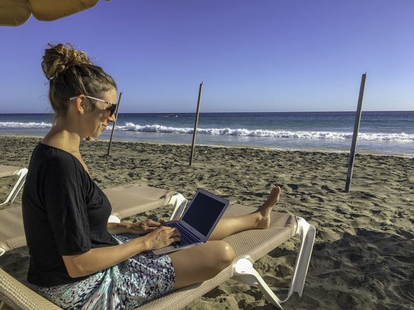 Digital nomad gadgets: working on my laptop at the beach in Fuerteventura