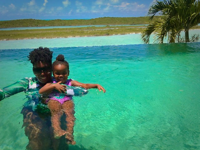 Mother with her daughter in turquoise water. 