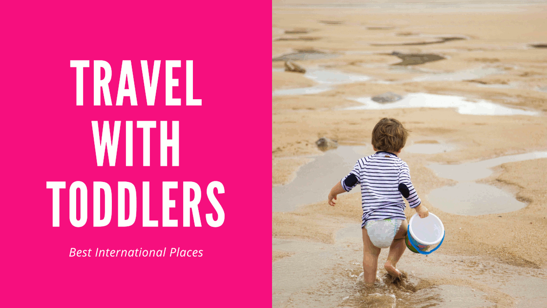 Blog graphic pink background with white letters saying 'Best international places to travel with toddlers'; on the right side: a toddler walking in the sand with a bucket in his hand.