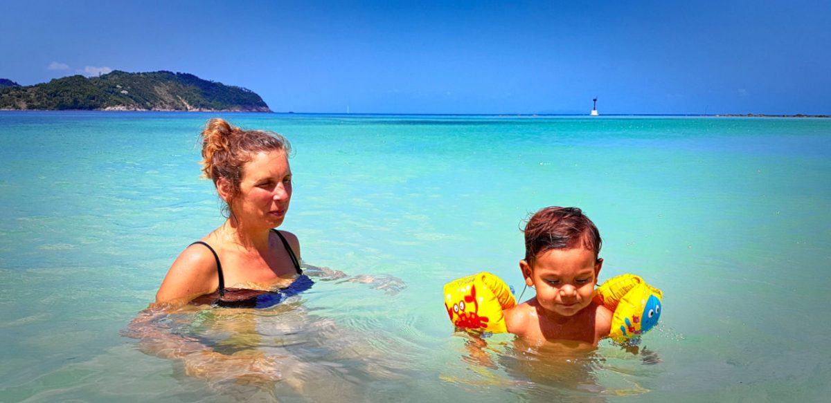 A mother and her toddler in turquoise water.