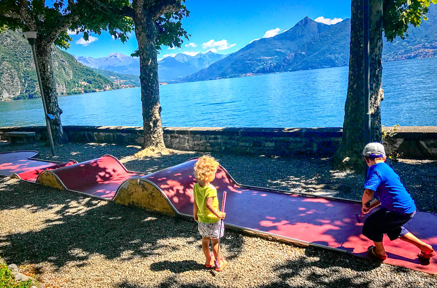 Two children playing mini-golf at Lake Como, Italy - one of the best international places to travel with toddlers.